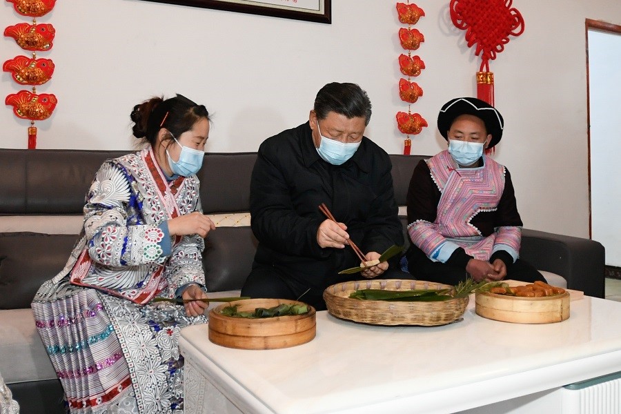 2021年2月3日下午，習(xí)近平在貴州畢節(jié)市黔西縣新仁苗族鄉(xiāng)化屋村苗族村民趙玉學(xué)家，同一家人邊聊家常邊制作當(dāng)?shù)貍鹘y(tǒng)節(jié)日食品黃粑。新華社記者 李學(xué)仁 攝