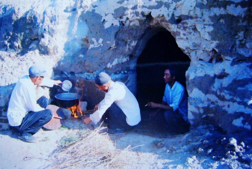 1983年，“六老漢”一代治沙人在“地窩子”生活做飯。新華社發(fā)（八步沙林場供圖）